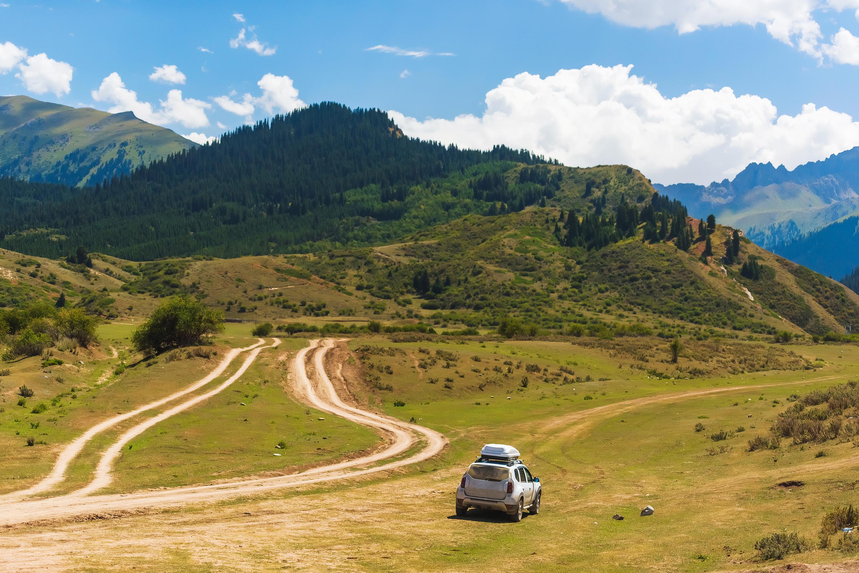 The car rides on hilly terrain. Mountain gorge Jeti Oguz. Rest in Kyrgyzstan. Nature in the area of lake Issyk Kul.