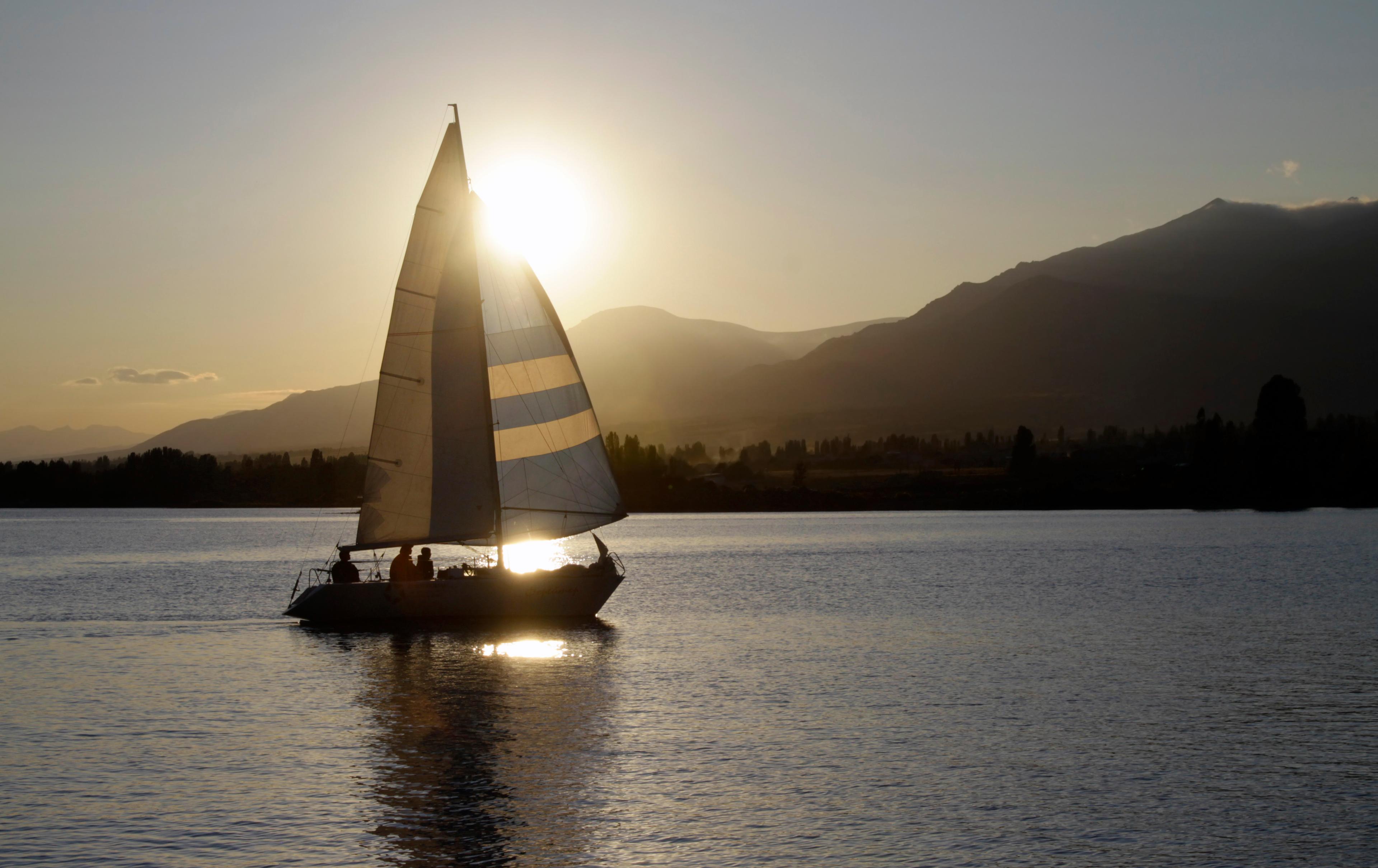 Sailing boat against the setting sun at lake Issyk-Kul in eastern Kyrgyzstan